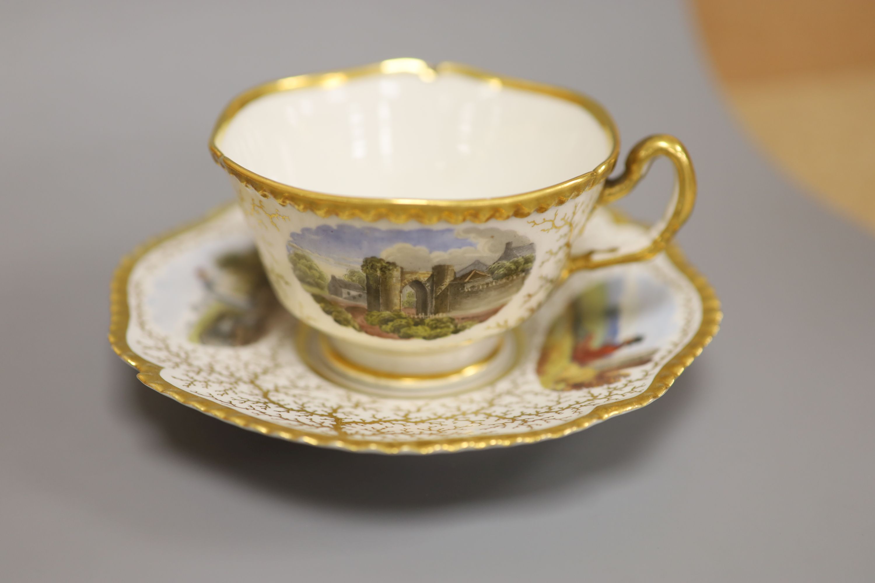 A Flight Barr & Barr cup and saucer, painted with Binstead cottage, Isle of White and Land Gate, Winchelsea, the saucer with country folk diameter 15cm